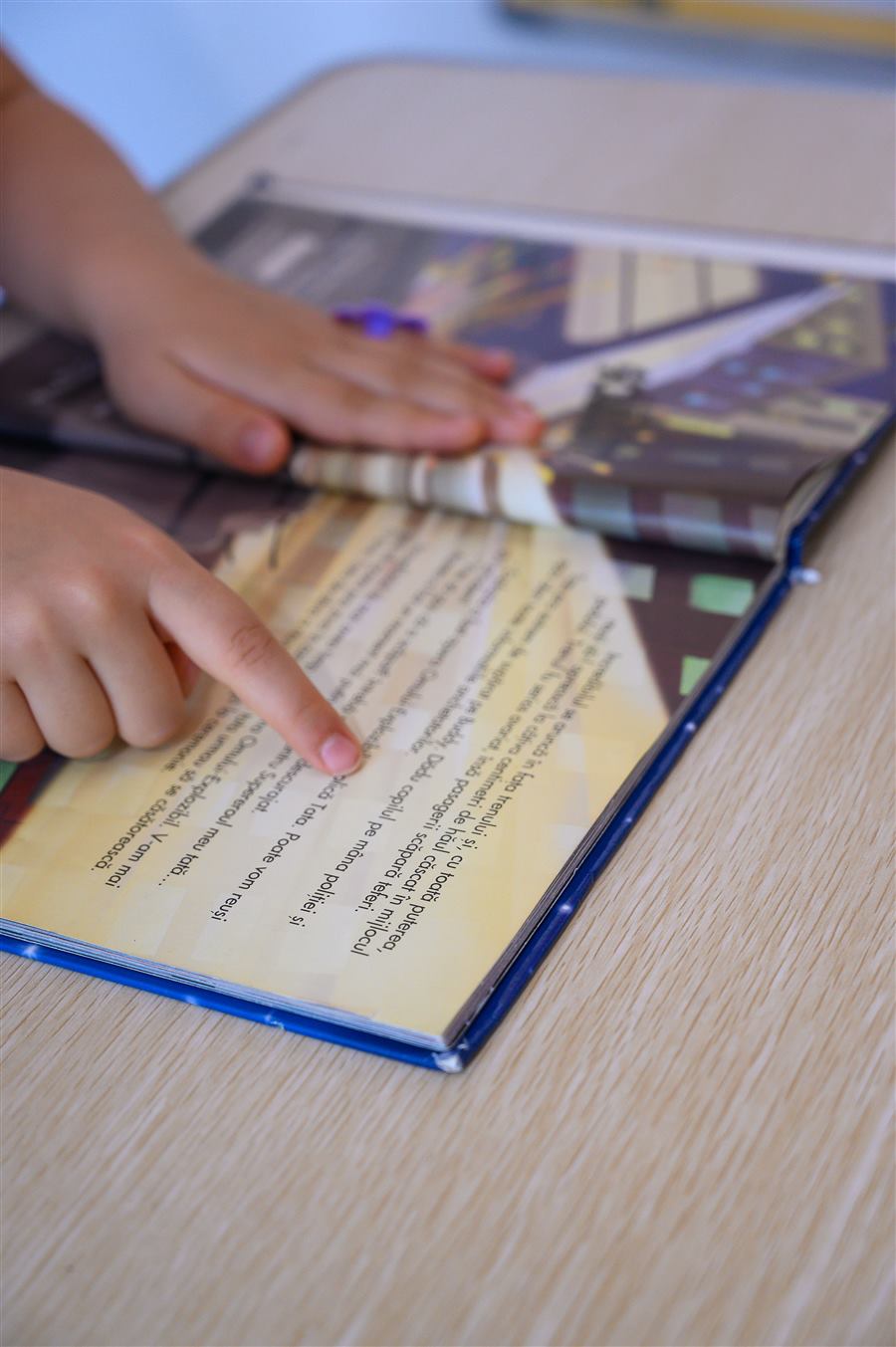 Copii citind și indicând textul dintr-o carte, sprijin la teme Astoria